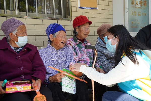 青年團員楊晴（右一）給老人們發(fā)放愛心物資。李春瑤攝