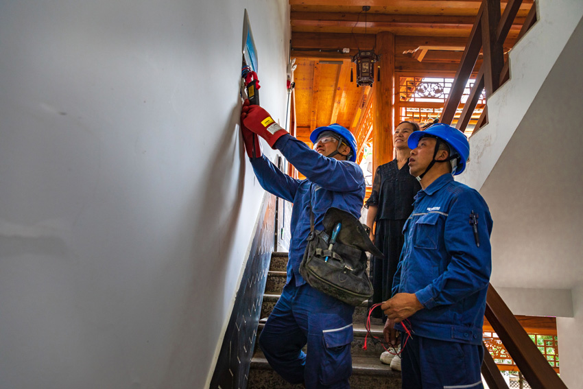 供電部門工作人員幫助避暑游客住宿的客棧處理用電問題。杜明彥攝