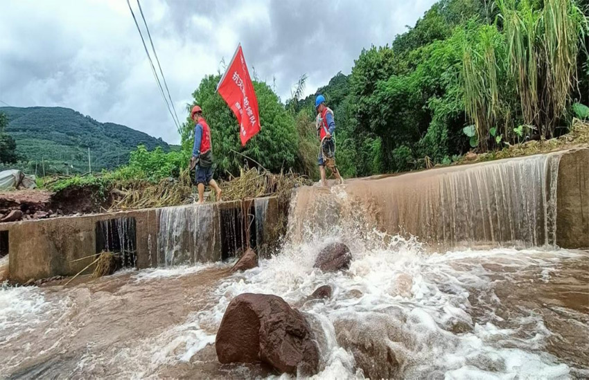 磨憨供電所黨支部黨員突擊隊涉水前往受災現場進行搶修作業(yè)。巖鳳攝