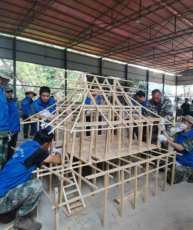 群眾在學(xué)習(xí)傣樓建造方法。景洪市人力資源和社會保障局供圖