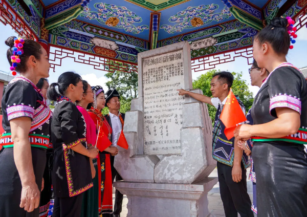 2024年9月25日，在位于云南省普洱市寧洱哈尼族彝族自治縣的民族團(tuán)結(jié)園里，當(dāng)?shù)厝罕妳⒂^民族團(tuán)結(jié)誓詞碑。新華社記者 王靜頤 攝