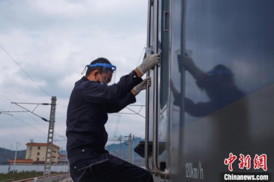 圖為民警查驗(yàn)列車。　磨憨邊檢站供圖